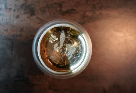 Ansicht eines Getränks von oben im Glas, mit reflektierendem Licht an der Oberfläche.