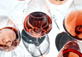 Roséwein-Gläser auf hellem Untergrund, mit Licht- und Schattenspiel.