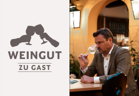 Mann im Anzug verkostet Wein in elegantem Raum.