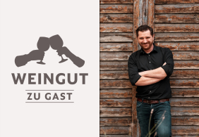 Mann in schwarzem Hemd vor rustikaler Holzwand stehend, stilisierte Weingläser links.