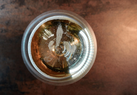 Ansicht eines Bieres von oben, in einem Glas, sanft schäumend.