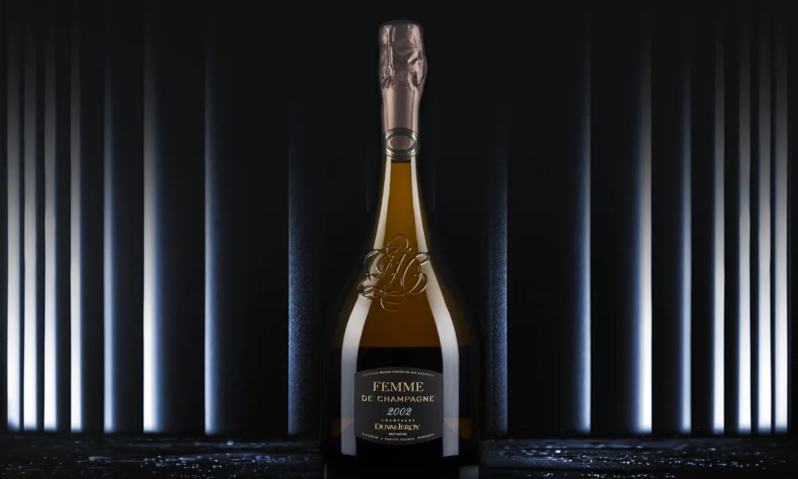 Elegante Champagnerflasche mit goldener Gravur vor monochromem, stilvollem Hintergrund.