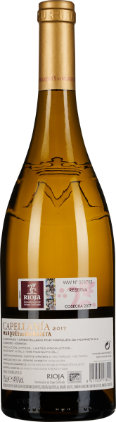 Transparente Weinflasche mit goldenem Etikett und hellem, klaren Wein.