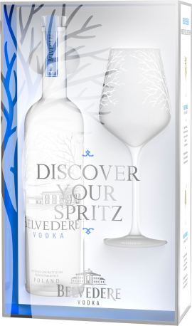 Geschenkset mit eleganter Flasche und Glas auf weißem, blau akzentuiertem Hintergrund.