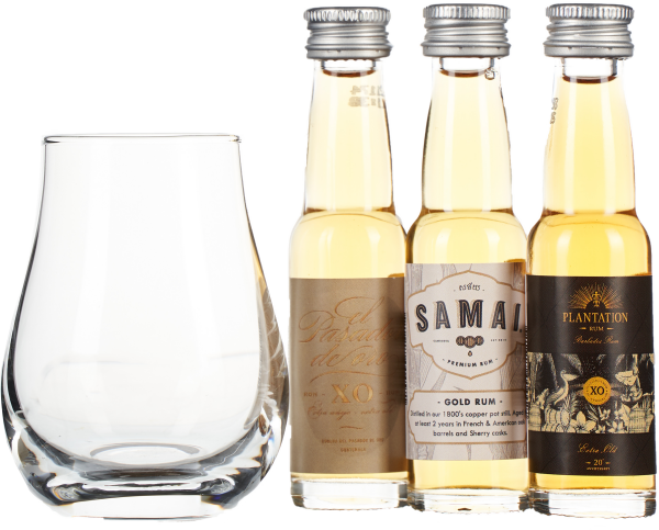 Set aus Whiskyglas und drei Mini-Rumflaschen mit goldener Flüssigkeit.