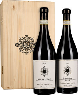 Zwei Weinflaschen mit eleganten, weißen Etiketten und schwarzen Verzierungen stehen vor einer stilvollen Holzkiste mit schwarzem Ornament.