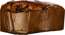 Brotähnlicher Kuchen in braunem Papier, goldbraune Kruste mit dunklen Fruchtstücken.