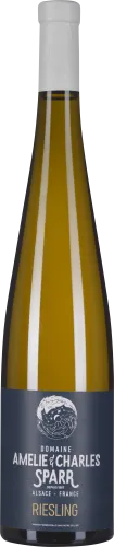 Eine schlanke Weinflasche mit goldgelbem Inhalt und blauem Etikett sowie weißem Verschluss.