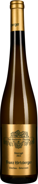 Weinflasche mit goldener Kapsel und Etikett, auf dem ein kunstvolles Logo in Schwarz zu sehen ist. Die Flasche hat ein elegantes, schlankes Design und das Etikett ist in edlem Goldton gehalten.