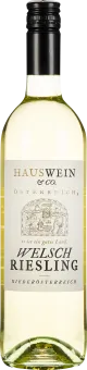 Eine Weinflasche mit hellem Etikett und schwarzem Verschluss. Im Vordergrund eine detaillierte Zeichnung einer ländlichen Szene. Der Wein hat eine klare, hellgelbe Farbe.
