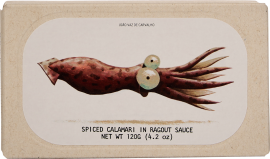 Eine rechteckige Verpackung mit einem geometrischen, stilisierten Tintenfisch in Rot- und Brauntönen auf cremigem Hintergrund. Der Tintenfisch hat große, auffällige Augen und lange Tentakeln. Darunter steht in schwarzer Schrift die Produktbeschreibung.