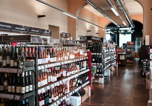 Weinladen mit modernen Regalen, gefüllt mit verschiedenen Weinflaschen und Spirituosen.